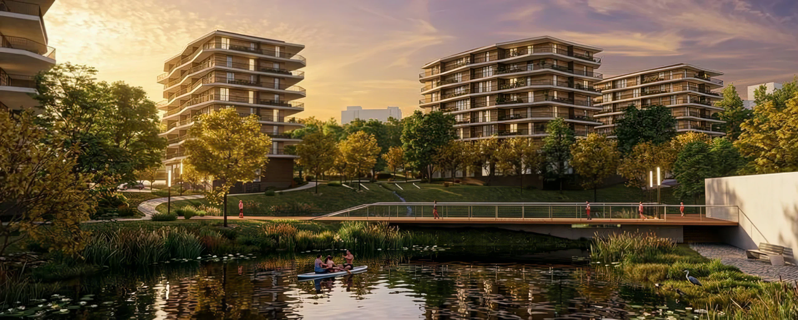 Tracking shot over the lake at sunset, with the footbridge crossing to the housing buildings.